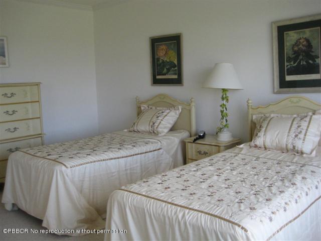 2175 Ibis Isle Road, Unit 4 Palm Beach, FL 33480 - Photo 7 of 9 a bedroom with a bed and a lamp on dresser