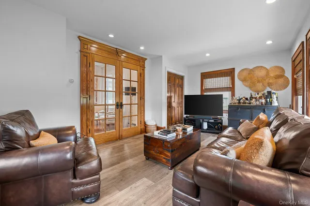 a living room with furniture a flat screen tv and a window