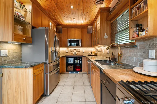 a kitchen with stainless steel appliances granite countertop a sink and a refrigerator