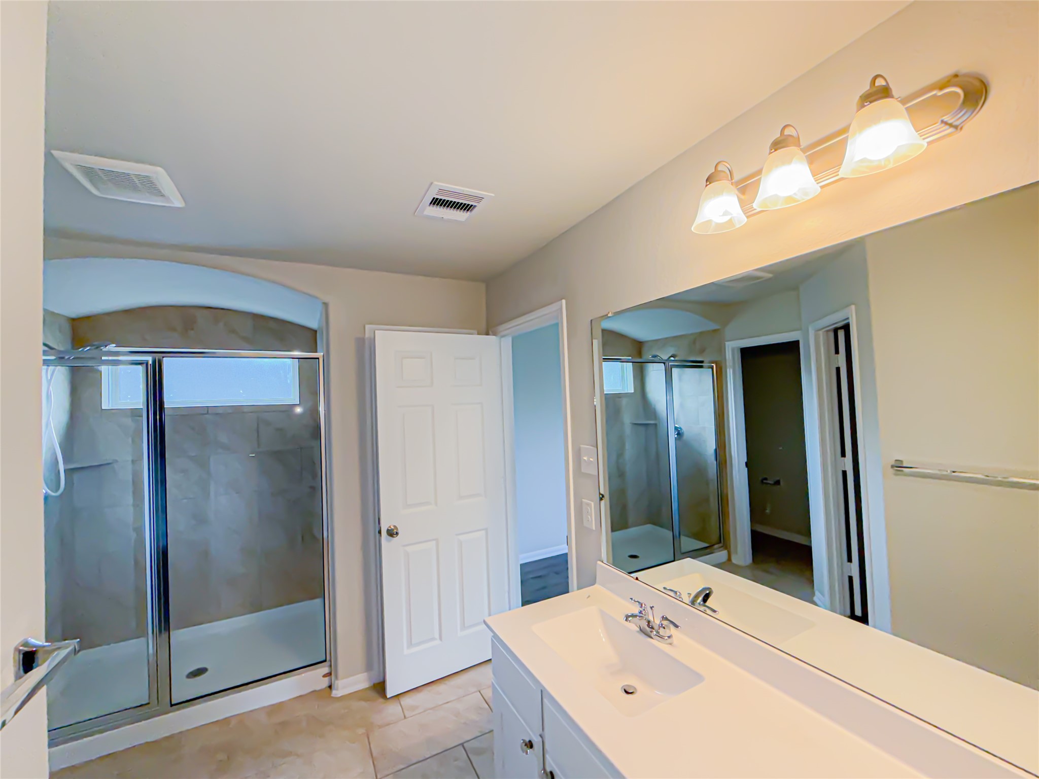 3323 Winchester Rnch Trail Katy, TX 77493 - Photo 18 of 22 The bathroom also includes a long vanity with ample counter space and a large mirror that enhances the room’s openness and natural light. Thoughtful layout and neutral finishes create a relaxing and versatile environment.