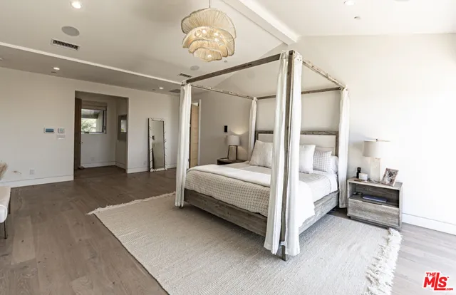 a bedroom with a large bed and a chandelier