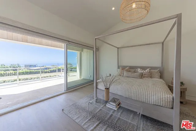 a bedroom with a bed and glass windows