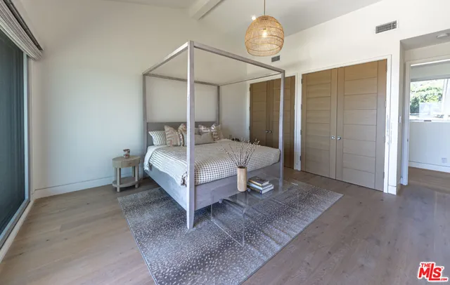 a spacious bedroom with a bed and a chandelier