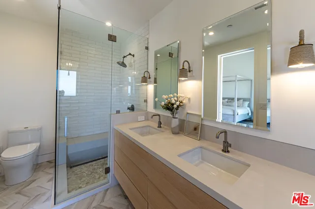 a bathroom with a double vanity sink toilet and shower
