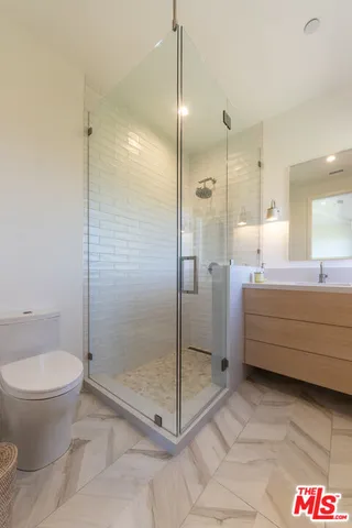 a bathroom with a shower a toilet and a sink
