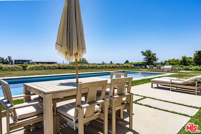 a view of swimming pool with outdoor seating and yard in the back