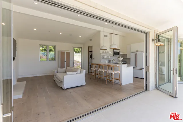 a living room with furniture and large windows