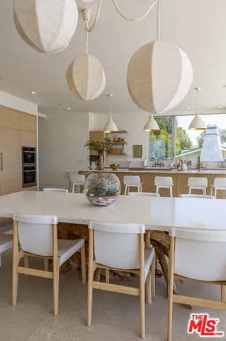 a kitchen with a dining table chairs and chandelier