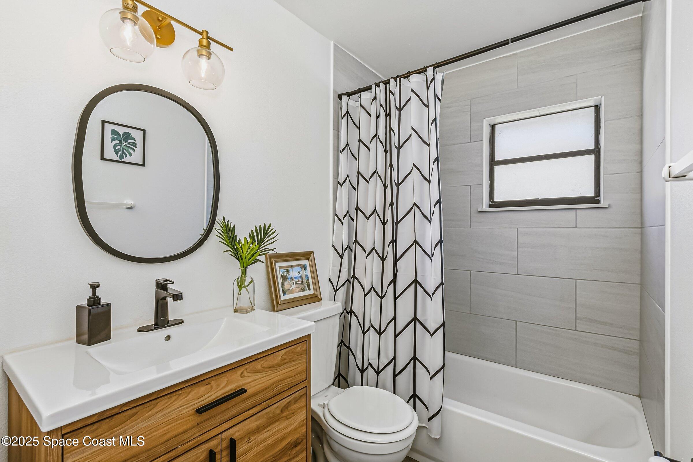 300 South Orlando Avenue, Unit 4 5 6 Cocoa Beach, FL 32931 - Photo 15 of 56 a bathroom with a sink a toilet and a mirror