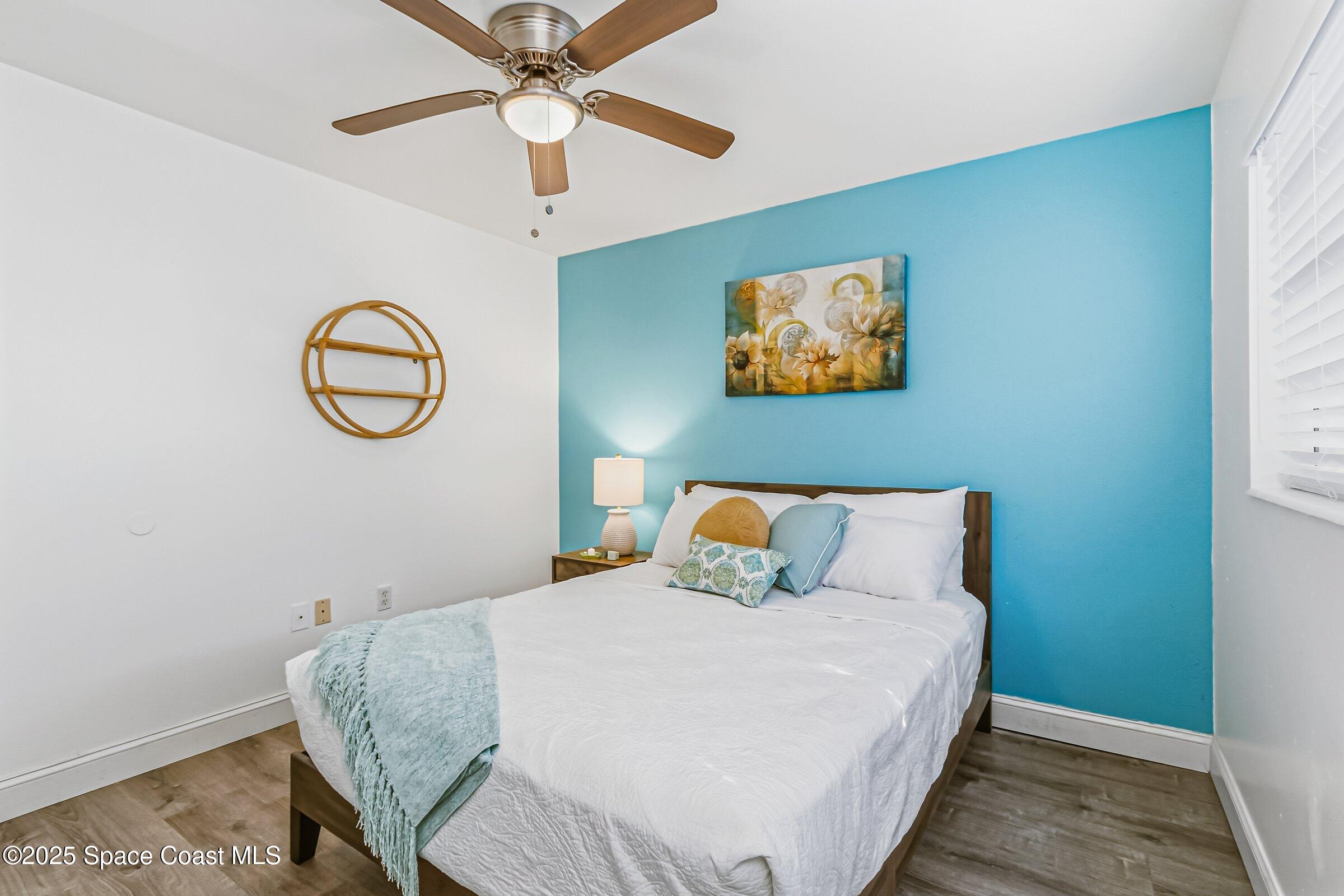 300 South Orlando Avenue, Unit 4 5 6 Cocoa Beach, FL 32931 - Photo 18 of 56 a bedroom with a bed and a chandelier