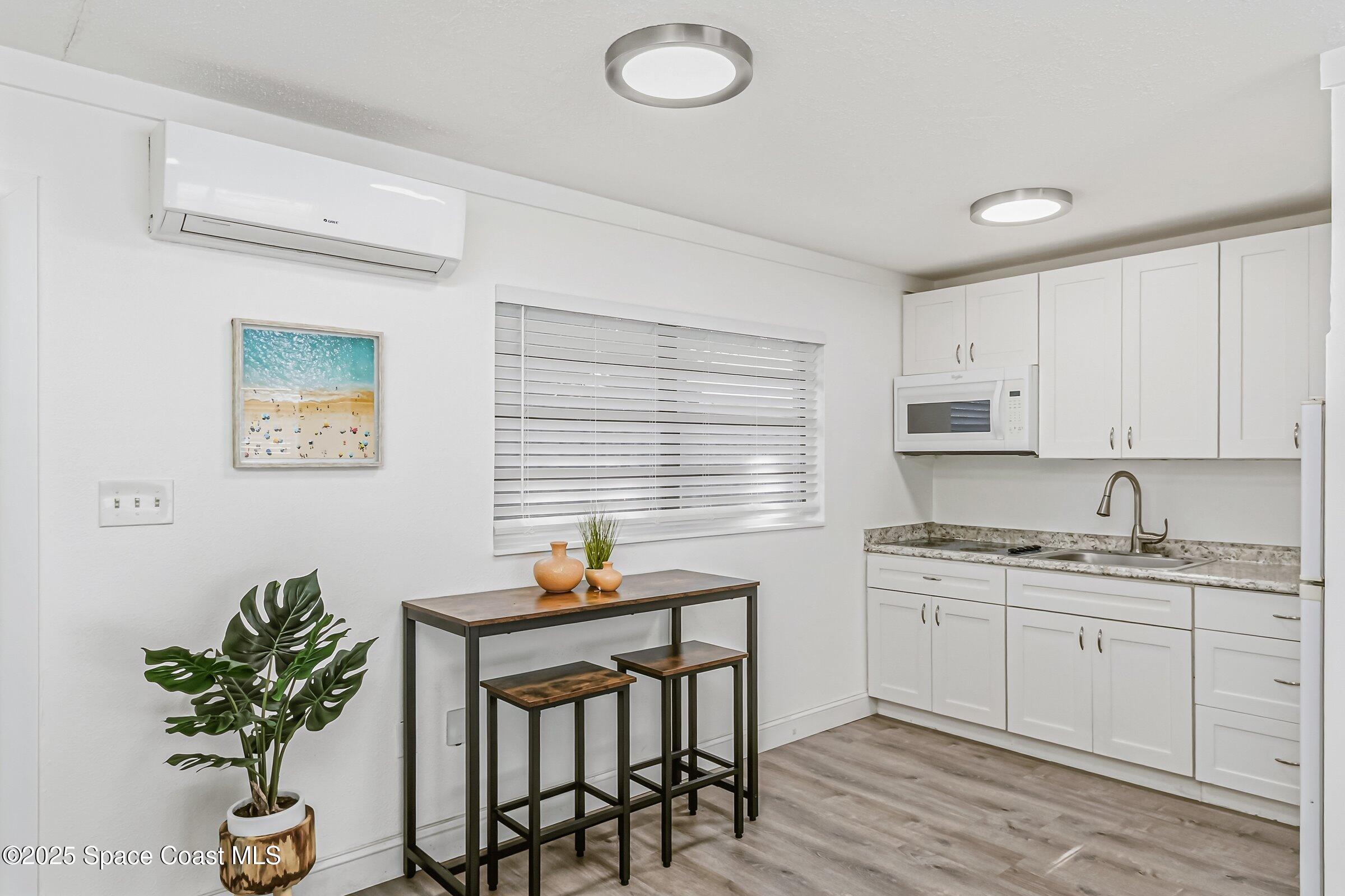 300 South Orlando Avenue, Unit 4 5 6 Cocoa Beach, FL 32931 - Photo 25 of 56 a kitchen with stainless steel appliances a sink a table and chairs in it