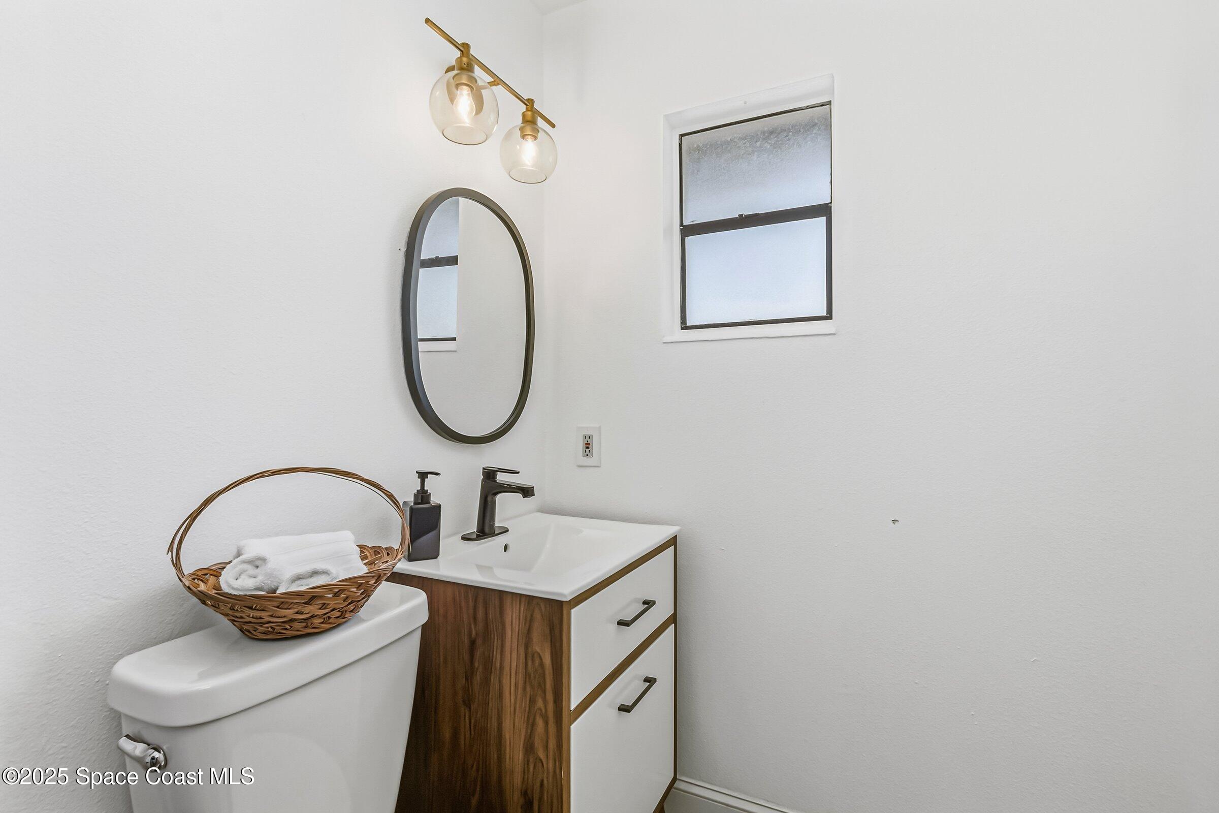 300 South Orlando Avenue, Unit 4 5 6 Cocoa Beach, FL 32931 - Photo 31 of 56 a bathroom with a granite countertop sink and a mirror