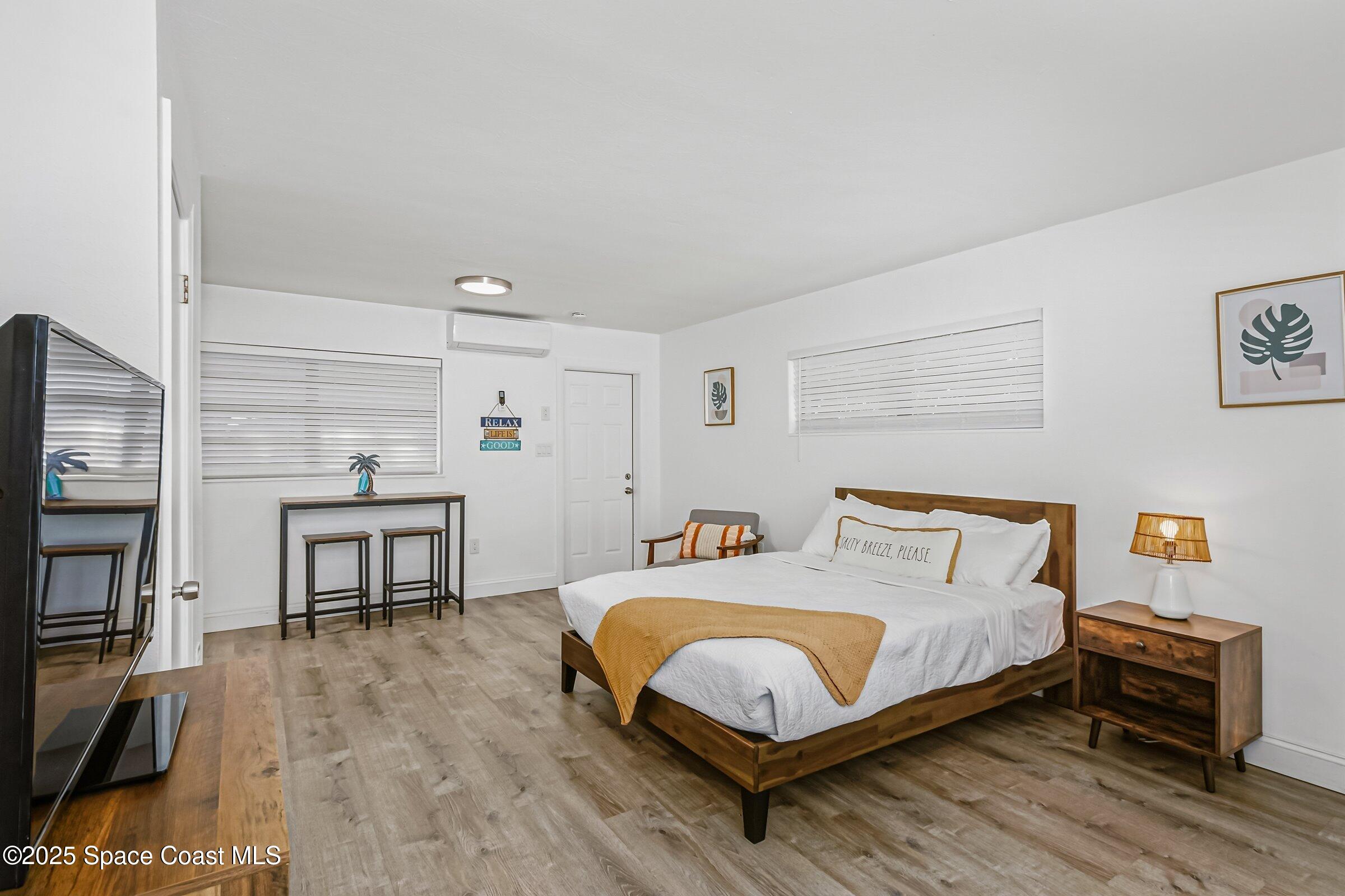 300 South Orlando Avenue, Unit 4 5 6 Cocoa Beach, FL 32931 - Photo 35 of 56 a bedroom with a bed table and a flat screen tv