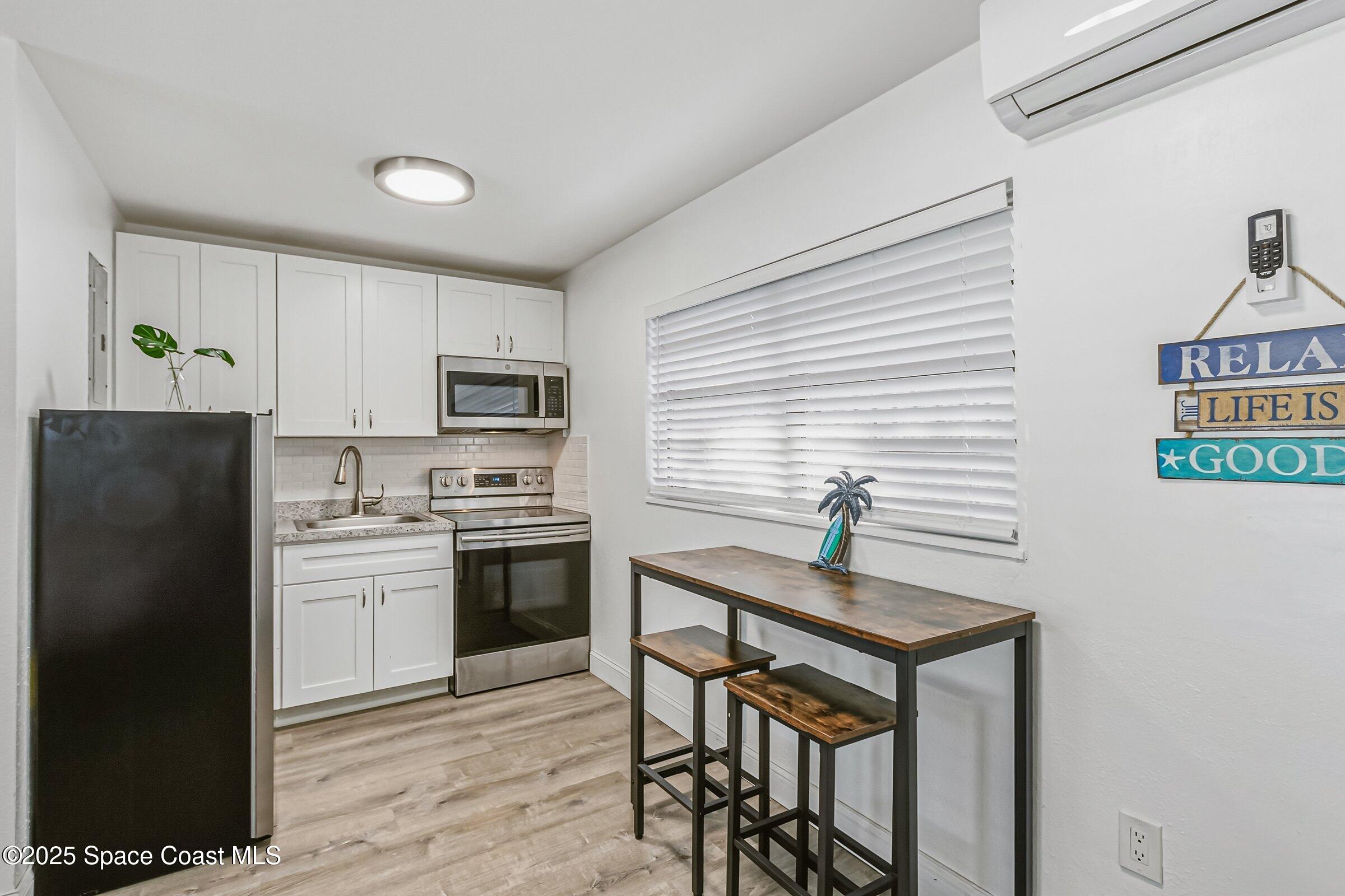 300 South Orlando Avenue, Unit 4 5 6 Cocoa Beach, FL 32931 - Photo 37 of 56 a kitchen with stainless steel appliances a stove a refrigerator sink and microwave