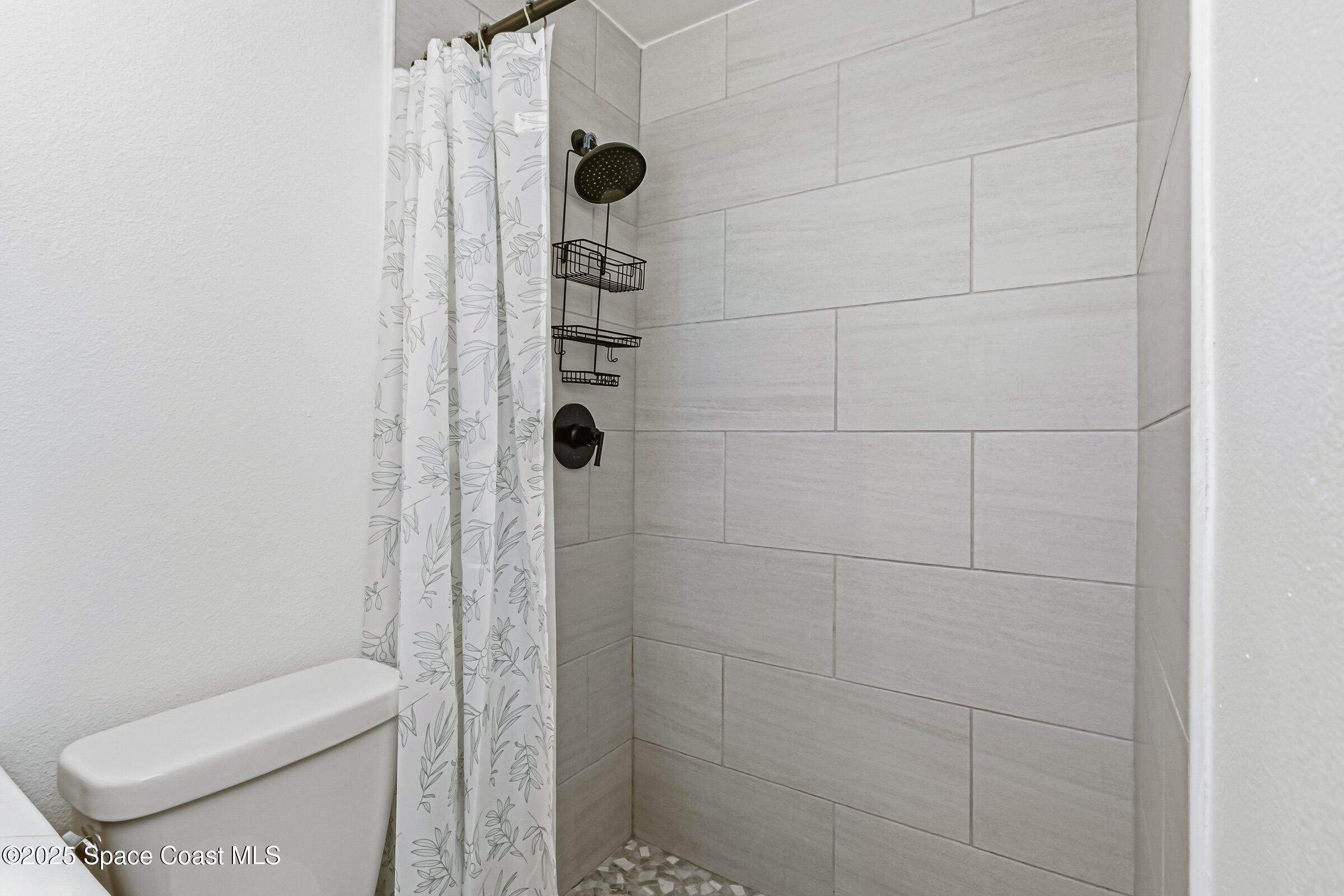 300 South Orlando Avenue, Unit 4 5 6 Cocoa Beach, FL 32931 - Photo 39 of 56 a bathroom with a toilet and shower
