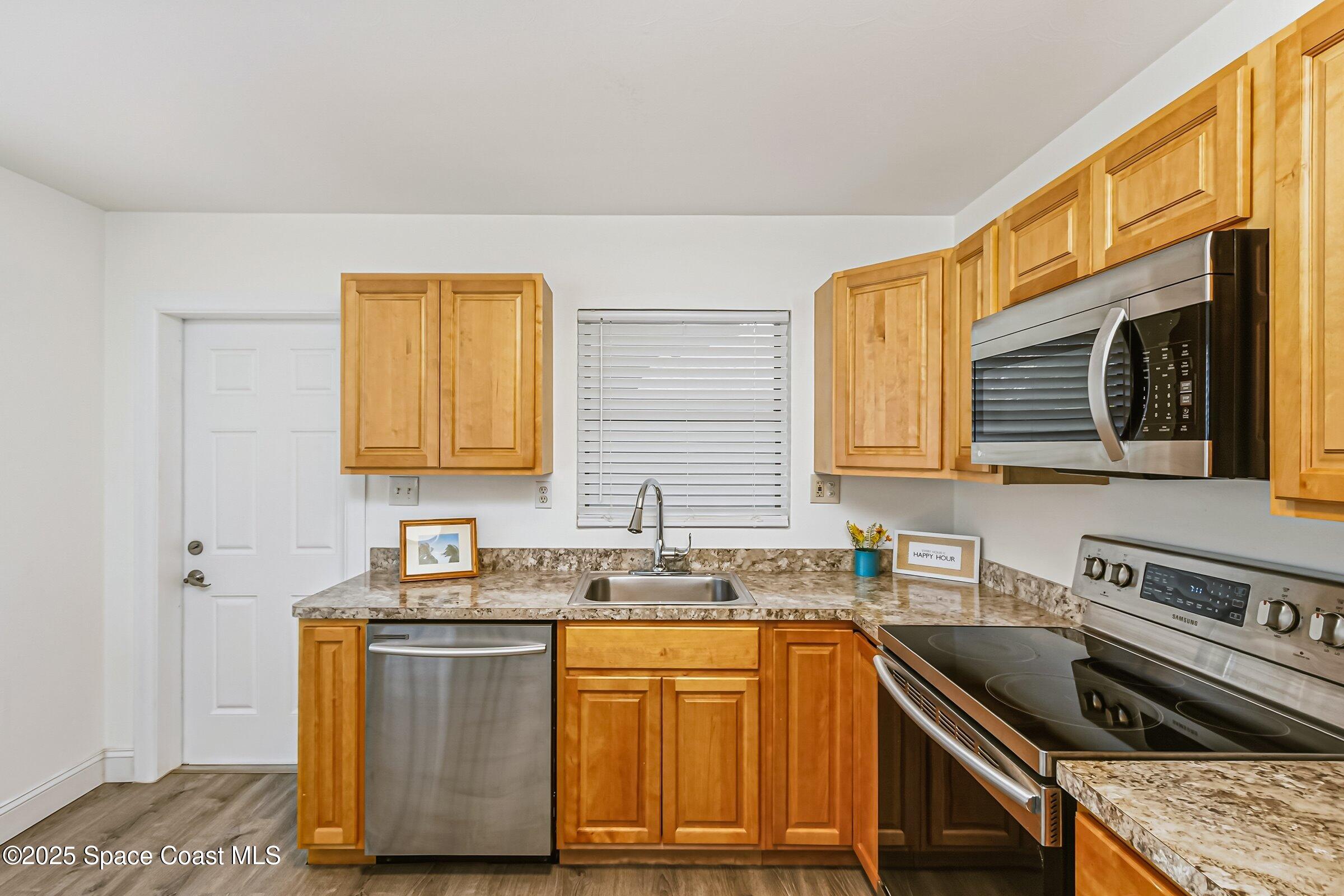 300 South Orlando Avenue, Unit 4 5 6 Cocoa Beach, FL 32931 - Photo 7 of 56 a kitchen with granite countertop a sink a stove and cabinets