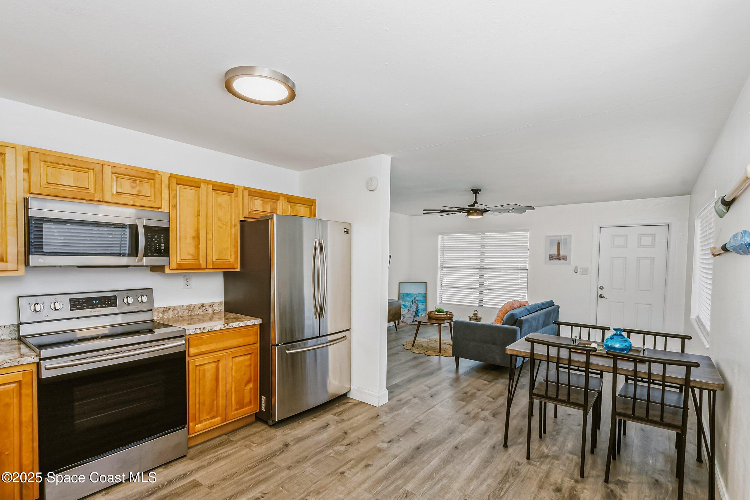 300 South Orlando Avenue, Unit 4 5 6 Cocoa Beach, FL 32931 - Photo 8 of 56 a kitchen with stainless steel appliances wooden floor and a refrigerator