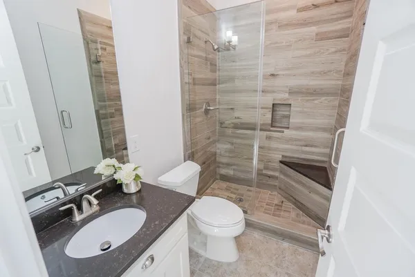 a bathroom with a sink a toilet and shower