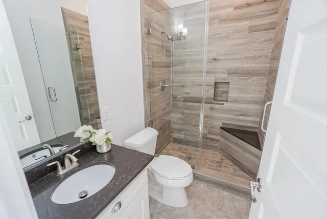 a bathroom with a sink a toilet and shower