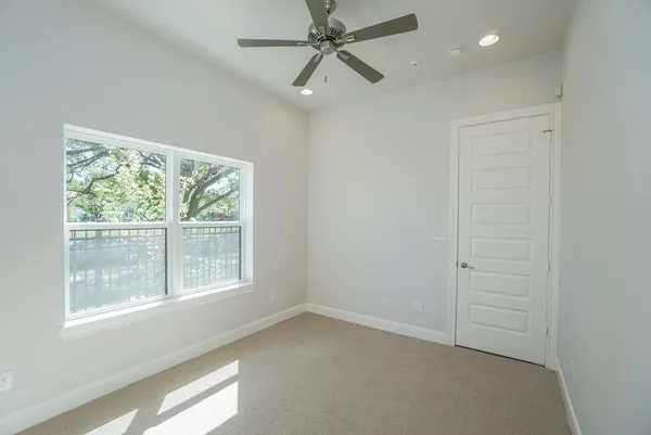 an empty room with a window and a fan