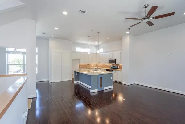 a room with wooden floors and ceiling fan