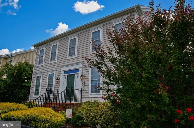 a front view of a house with plants and trees