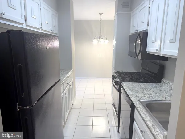 a kitchen with granite countertop a refrigerator and a stove