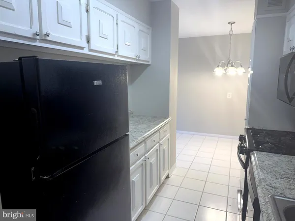 a kitchen with granite countertop a refrigerator a stove and a sink