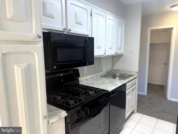 a kitchen with granite countertop a stove and a sink