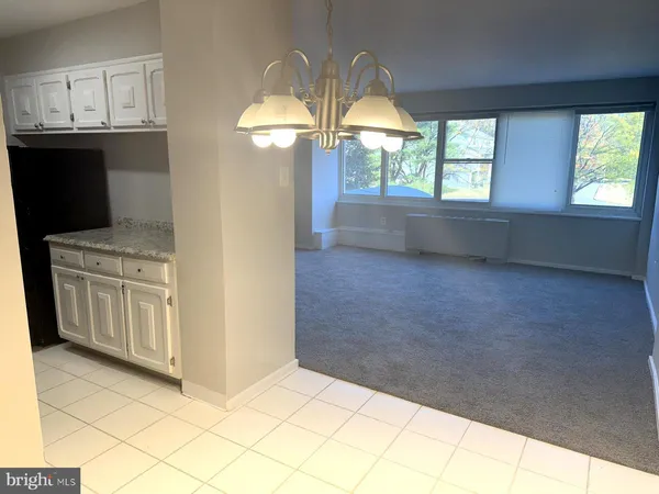 a kitchen with white cabinets and window