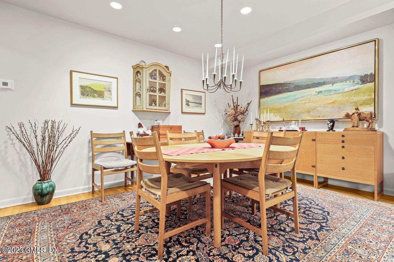 236 Riverside Avenue Riverside, CT 06878 - Photo 13 of 40 a dining room with wooden floor a chandelier a wooden table and chairs