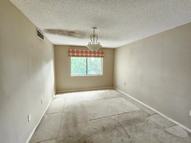 an empty room with windows and cabinet