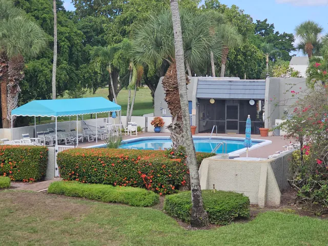 a view of a house with backyard and swimming pool