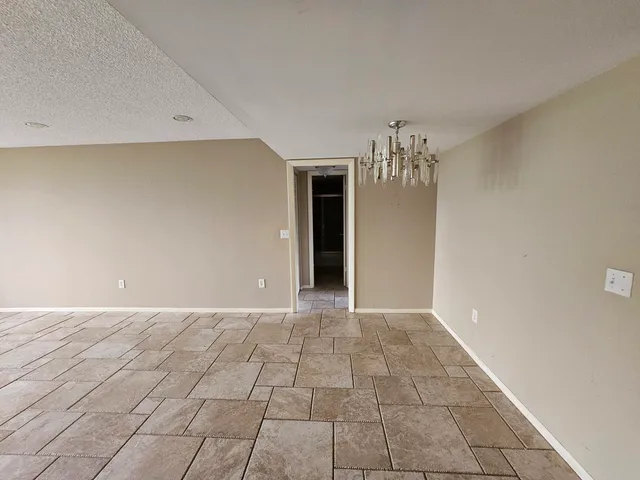 a view of an empty room with a chandelier