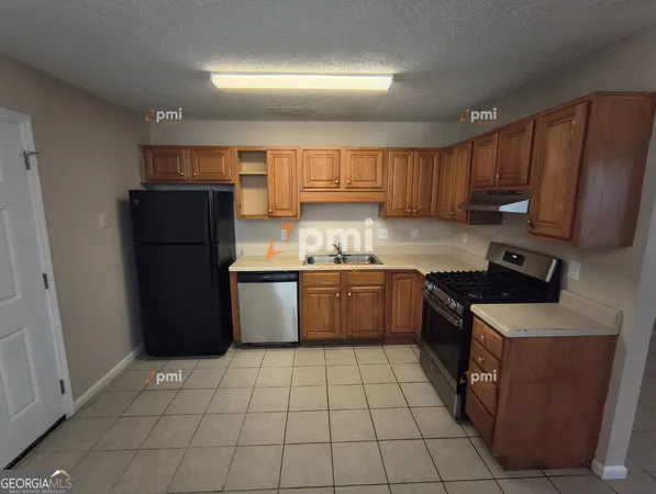 a kitchen with a stove a refrigerator a sink and cabinets