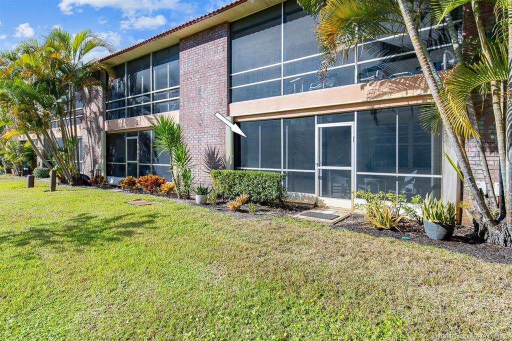 1909 Southwest Palm City Road, Unit B Stuart, FL 34994 - Photo 20 of 36 a front view of a house with a yard and outdoor seating