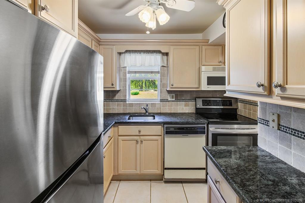 1909 Southwest Palm City Road, Unit B Stuart, FL 34994 - Photo 7 of 36 a kitchen with stainless steel appliances granite countertop a sink stove and refrigerator