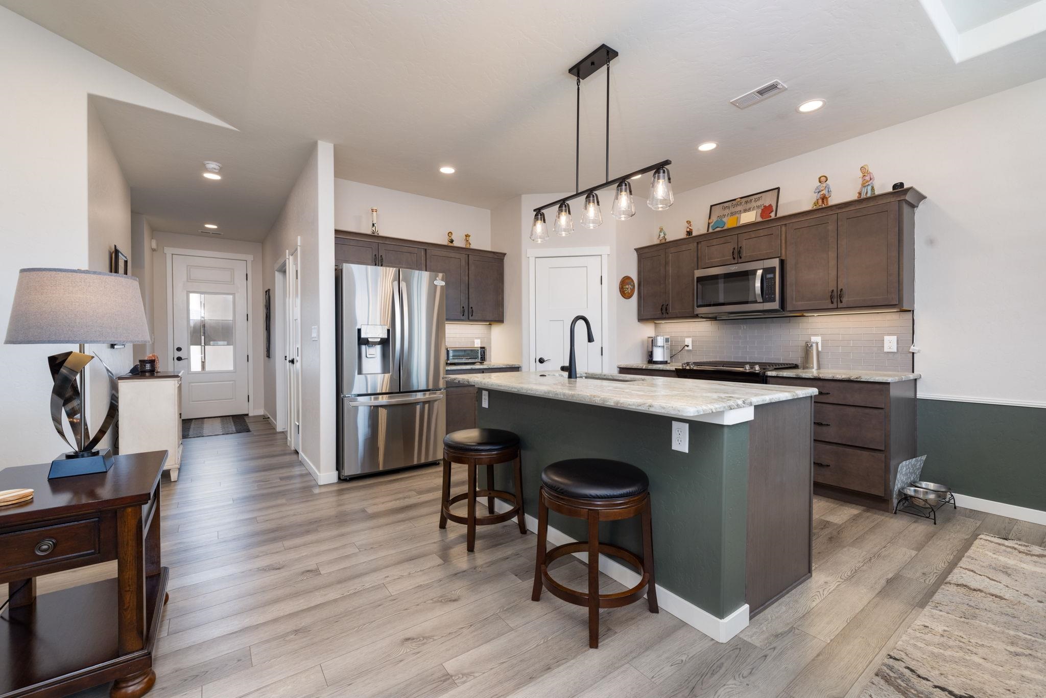 2454 Ross Road Grand Junction, CO 81505 - Photo 14 of 31 a kitchen with stainless steel appliances kitchen island granite countertop a sink refrigerator and microwave