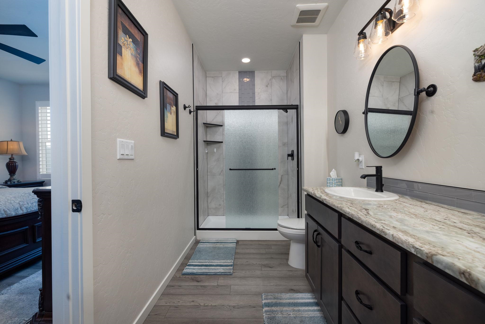 2454 Ross Road Grand Junction, CO 81505 - Photo 26 of 31 a bathroom with a granite countertop shower a mirror and a sink