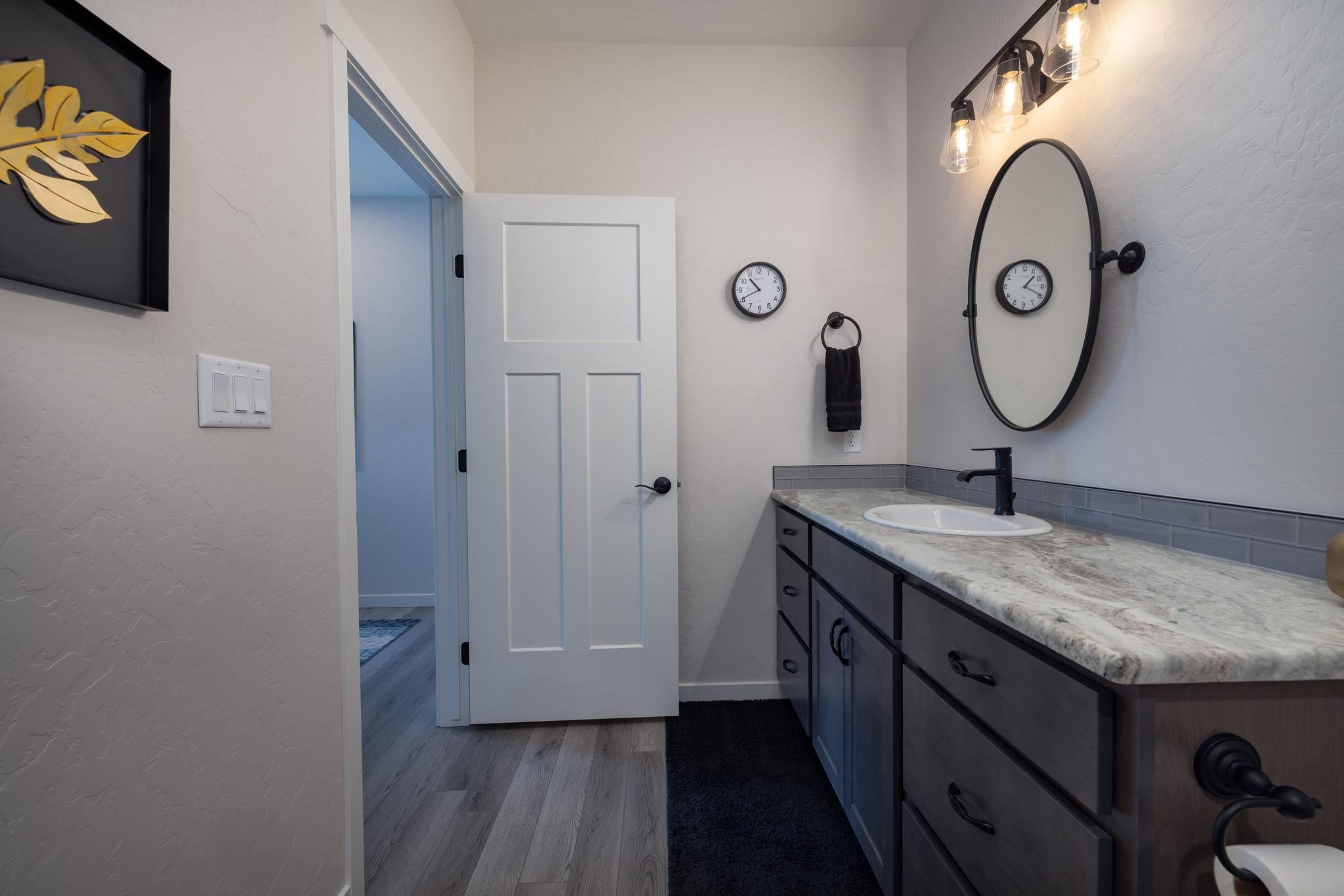 2454 Ross Road Grand Junction, CO 81505 - Photo 8 of 31 a bathroom with a granite countertop sink and a mirror