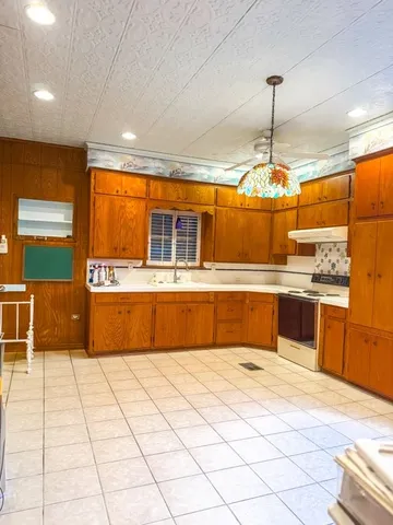 a kitchen with stainless steel appliances kitchen island granite countertop a refrigerator and a stove top oven