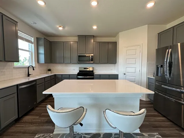 a kitchen with a table chairs sink and refrigerator