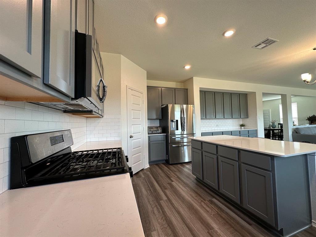 4553 Dugenta Place Round Rock, TX 78665 - Photo 14 of 38 a kitchen with stainless steel appliances a sink stove and refrigerator