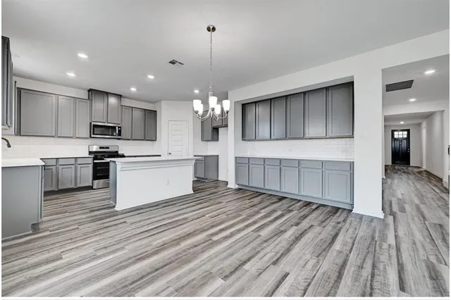 a large kitchen with kitchen island a sink stainless steel appliances and cabinets