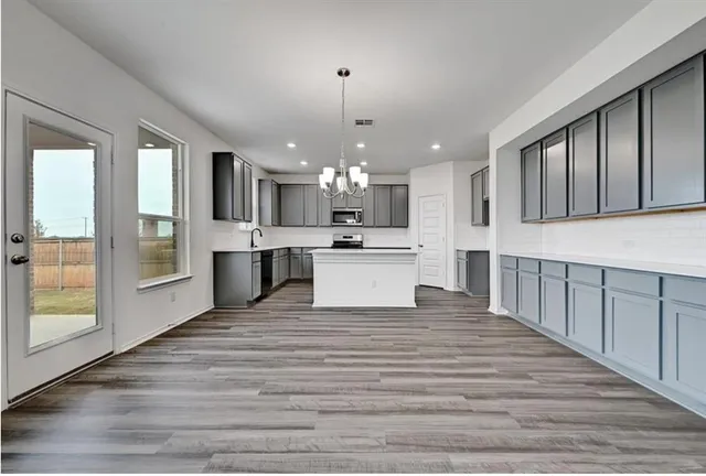 a view of kitchen with granite countertop cabinets and refrigerator