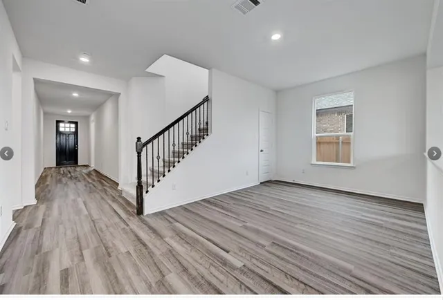 a view of a hallway with wooden floor and staircase