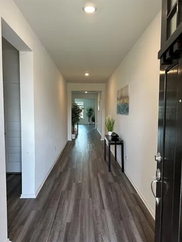 a hallway with wooden floor fireplace and livingroom