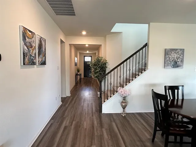 a view of a hallway with wooden floor and stairs