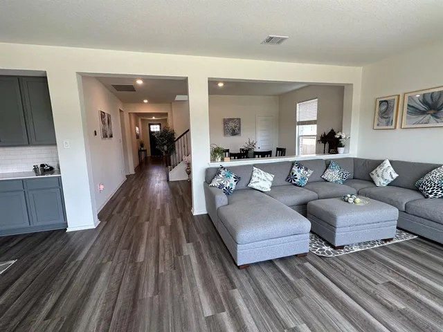 a living room with couches and a potted plant on dresser