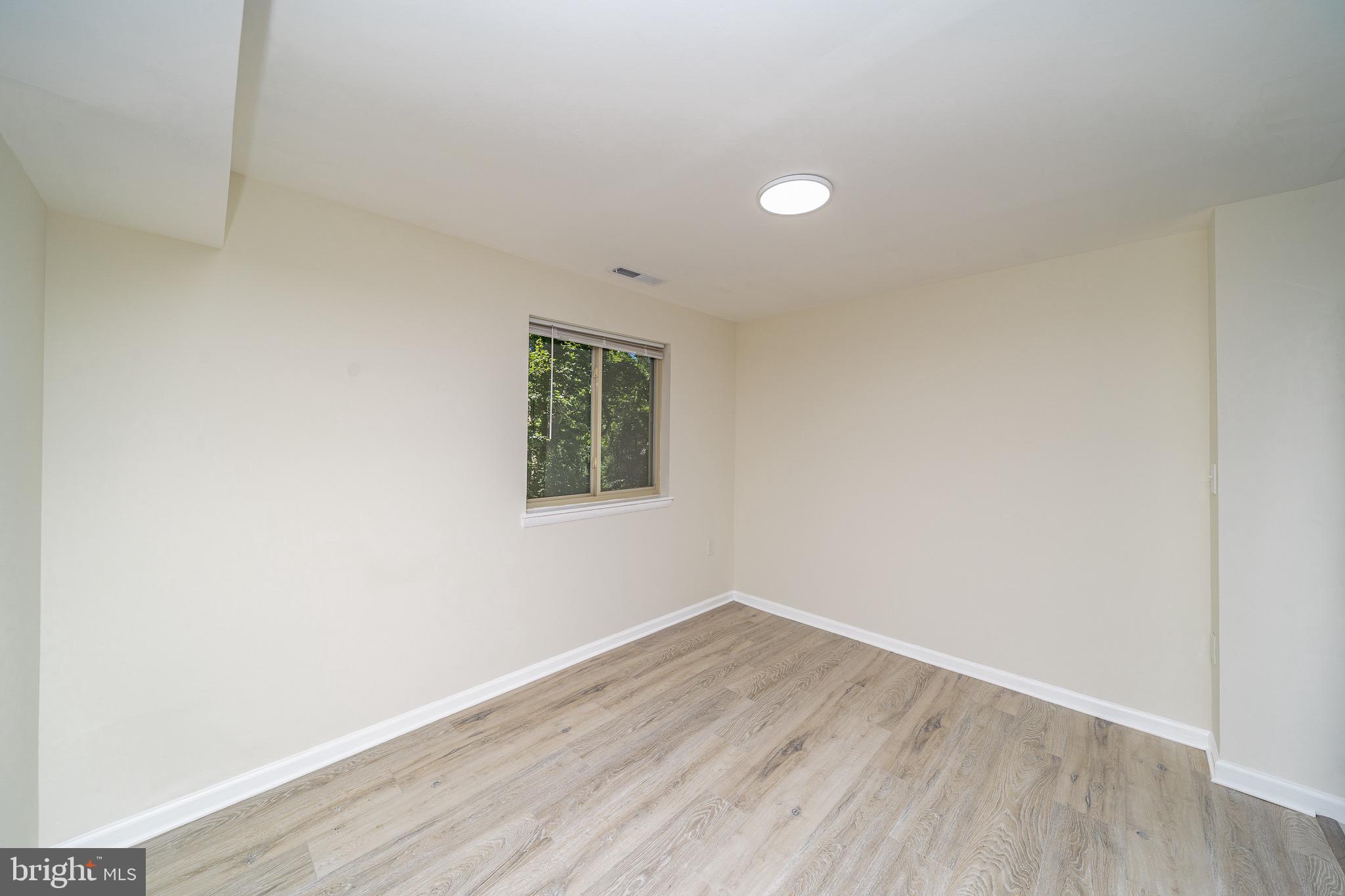 9910 Walker House Road, Unit 99104 Gaithersburg, MD 20886 - Photo 4 of 32 an empty room with wooden floor and windows